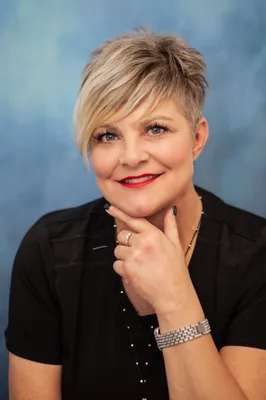 A woman with short hair is posing for the camera.